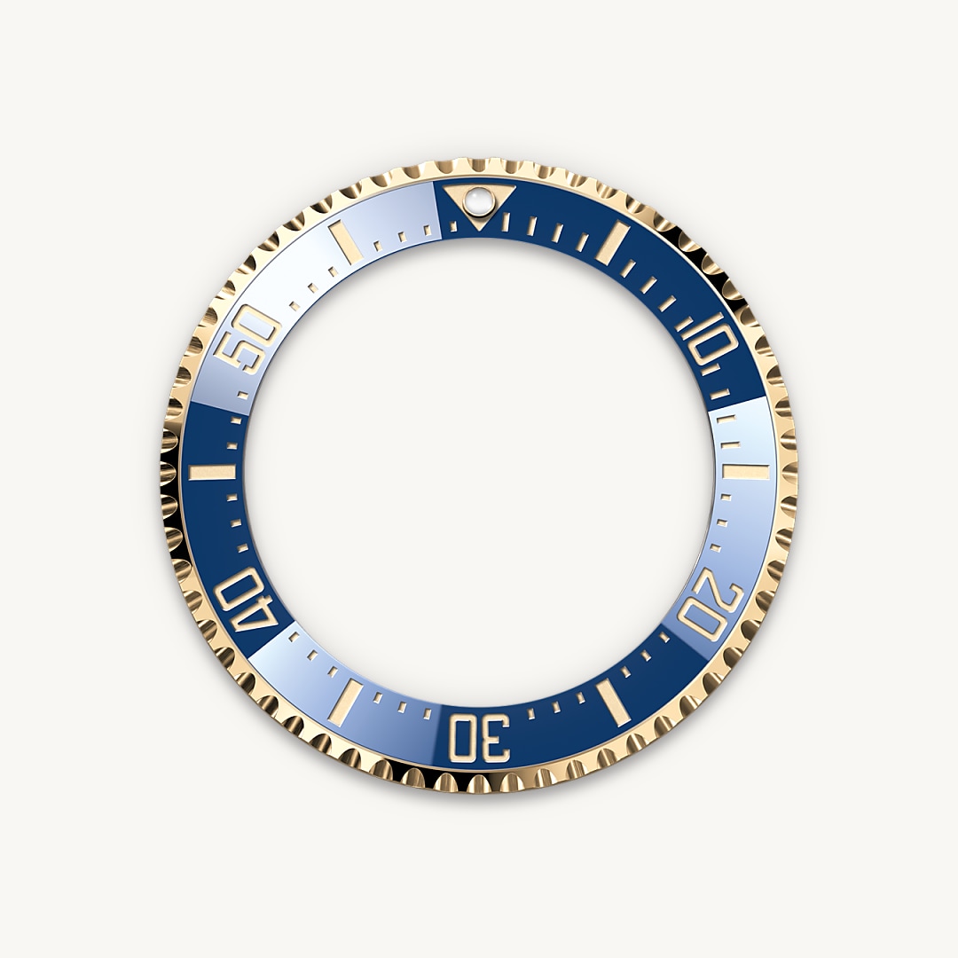 The 60-minute graduated, unidirectional rotatable bezel of the Rolex Deepsea enables divers to precisely and safely monitor their dive and decompression times. The triangular ‘zero’ marker of the graduation is visible in the dark thanks to an embedded capsule containing a luminescent material emitting a long-lasting blue glow. The graduation on the bezel is coated via PVD (Physical Vapour Deposition) with a thin layer of yellow gold.
The blues found in the compression ring, the dial and the Cerachrom bezel insert combine to create a subtle oceanic palette that is accentuated by the 18 ct yellow gold of the case and the Oyster bracelet.