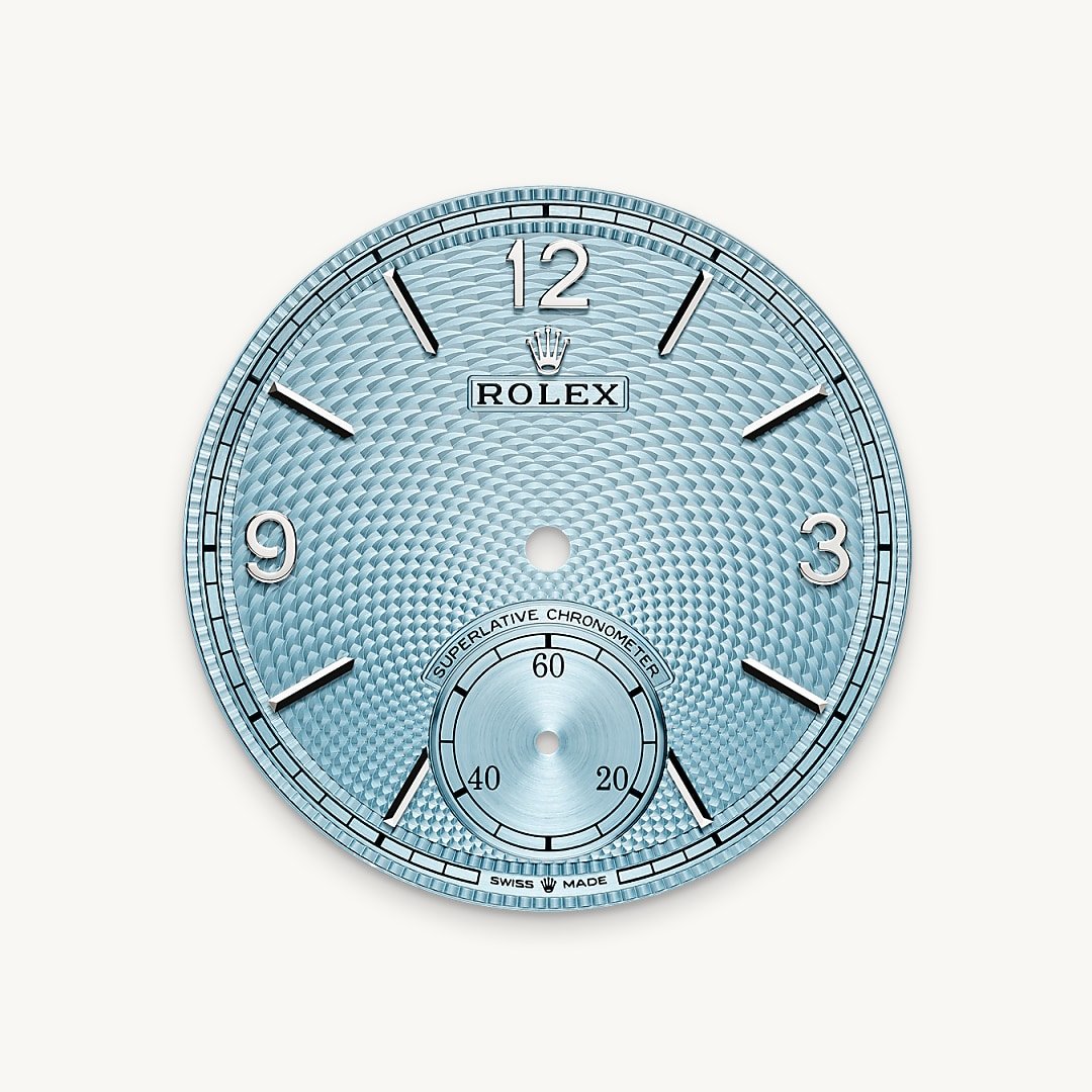 The ice blue dial features a guilloché rice-grain motif. This rosette-like design is distinctive for its three-dimensional, repeating geometric pattern that extends across the surface of the dial starting from the small seconds counter at 6 o’clock. The minute track is surrounded by a filet sauté with crimped pattern, which is also guilloché. With the introduction of a dial created via guillochage, or engine turning – a technique that uses a turning tool to sculpt a pattern into a surface – Rolex is pursuing the course it has set for the Perpetual collection as a tribute to the classic art of watchmaking infused with the brand’s know-how and creativity. This exclusive dial bears the same Arabic numerals 3, 9 and 12, the same faceted hour markers and the same hands as that of the 18 ct gold versions.
This exclusive dial colour can be found only on the Day-Date, the Cosmograph Daytona and the Perpetual 1908.