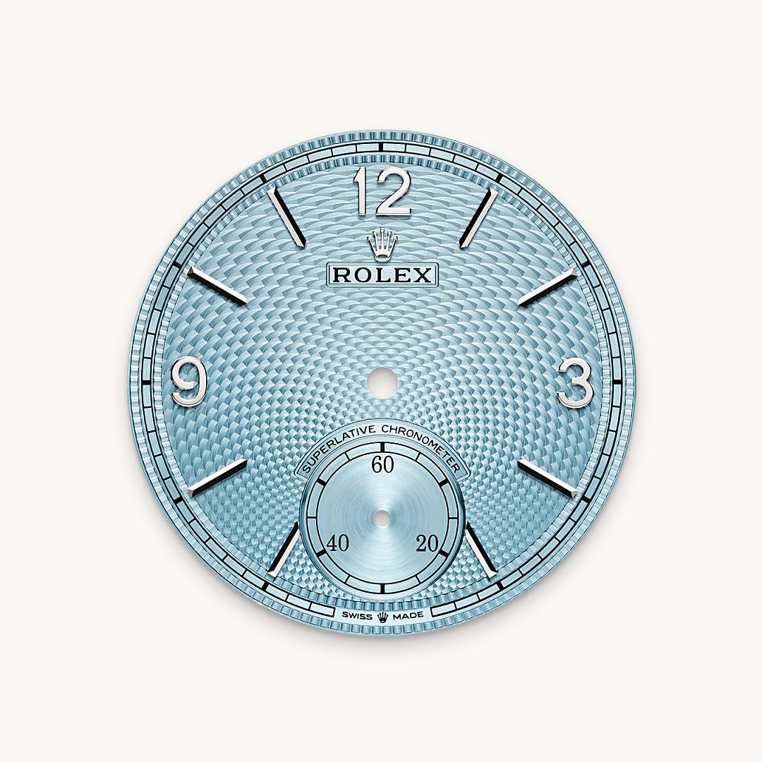 The ice blue dial features a guilloché rice-grain motif. This rosette-like design is distinctive for its three-dimensional, repeating geometric pattern that extends across the surface of the dial starting from the small seconds counter at 6 o’clock. The minute track is surrounded by a filet sauté with crimped pattern, which is also guilloché. With the introduction of a dial created via guillochage, or engine turning – a technique that uses a turning tool to sculpt a pattern into a surface – Rolex is pursuing the course it has set for the Perpetual collection as a tribute to the classic art of watchmaking infused with the brand’s know-how and creativity. This exclusive dial bears the same Arabic numerals 3, 9 and 12, the same faceted hour markers and the same hands as that of the 18 ct gold versions. 

This exclusive dial colour can be found only on the Day-Date, the Cosmograph Daytona, the Perpetual 1908 and the Land-Dweller.